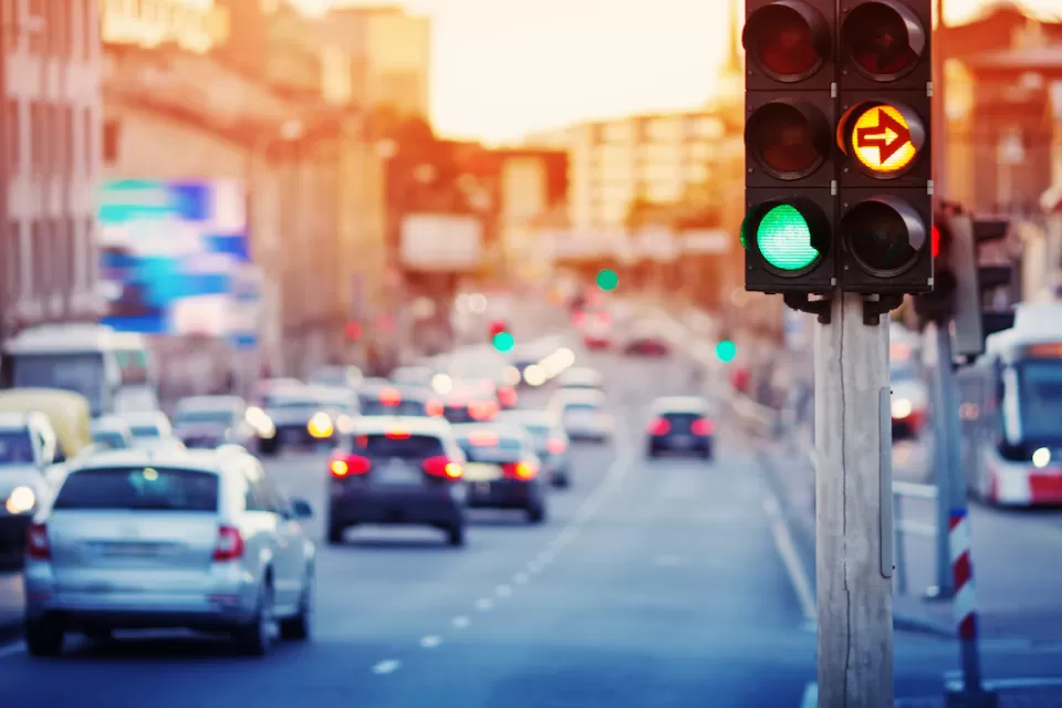 Traffic light with blurred cars and streetcar in background.